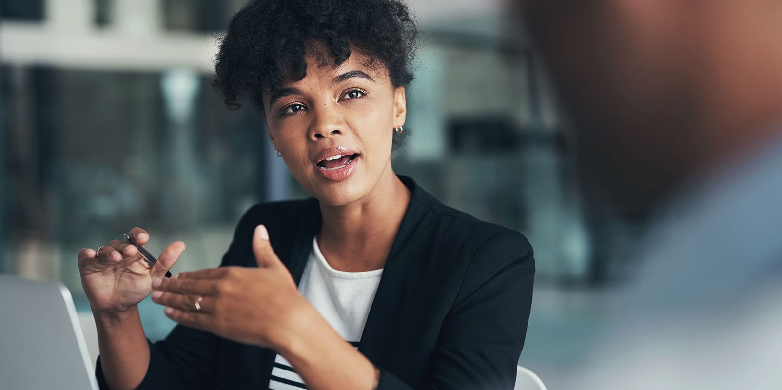 A business woman speaks in a meeting.