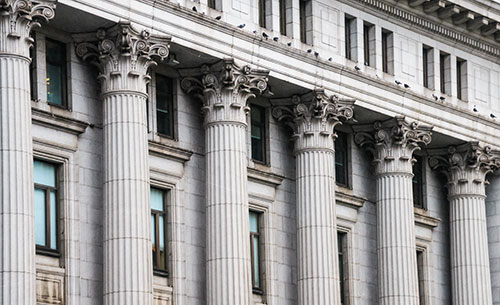 A series of architectural columns on the exterior of a financial institution.