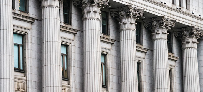 A series of architectural columns on the exterior of a financial institution.